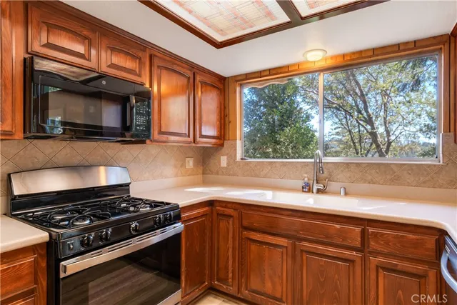 a kitchen with stainless steel appliances granite countertop a sink stove and cabinets