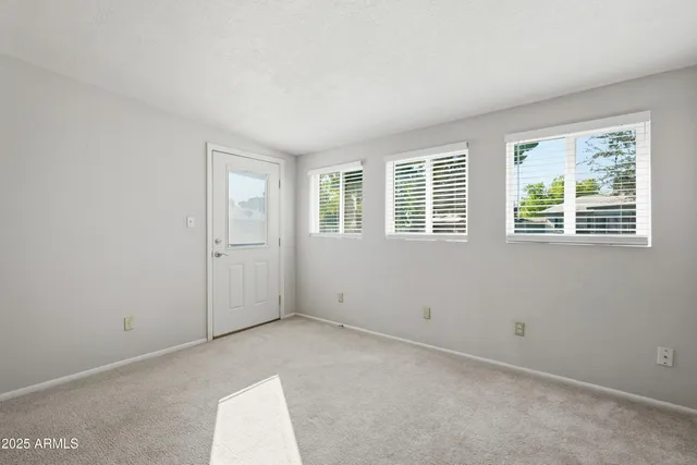 an empty room with a ceiling fan and window