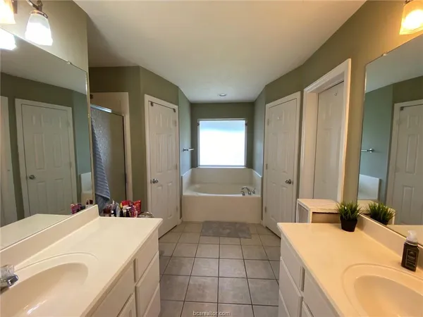 a spacious bathroom with a granite countertop sink and a mirror