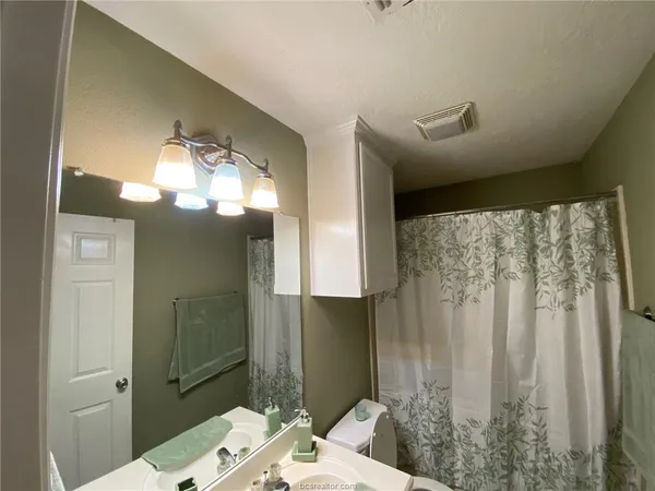 a bathroom with a sink vanity granite and a mirror