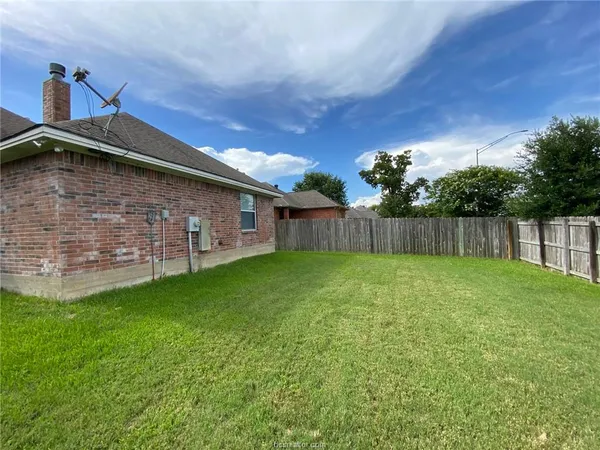 a view of a backyard with large trees