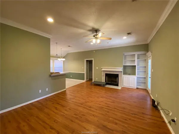 a view of an empty room with a fireplace and a window
