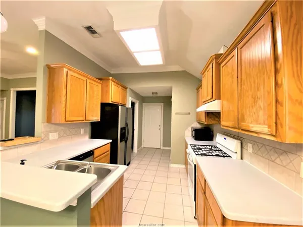 a kitchen with stainless steel appliances kitchen island granite countertop a sink and cabinets