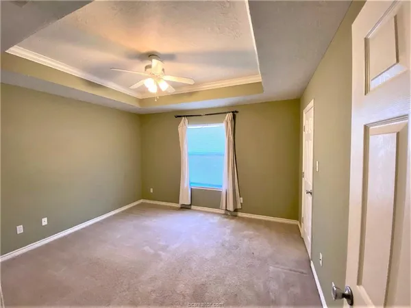 an empty room with a ceiling fan and a window