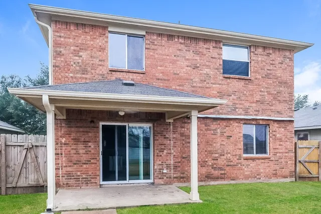 front view of a brick house with a yard