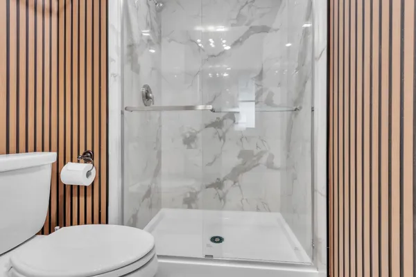 a bathroom with a toilet and a shower