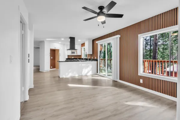 a view of a kitchen with a stove cabinets a ceiling fan and wooden floor