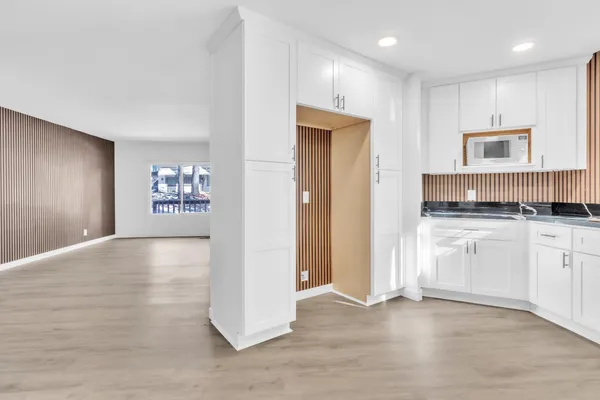 a view of kitchen with granite countertop cabinets and refrigerator
