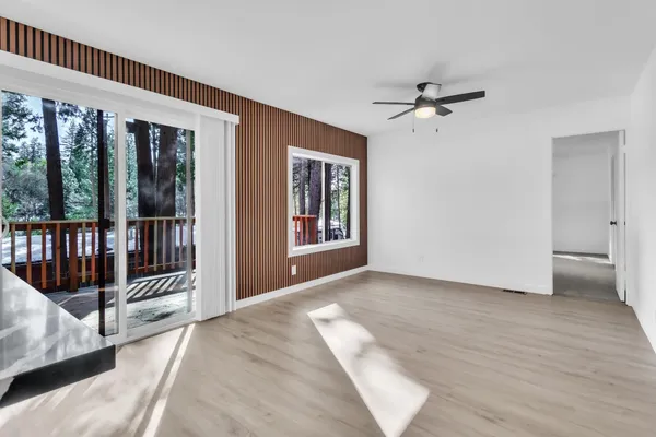 a view of a big room with wooden floor fan and windows