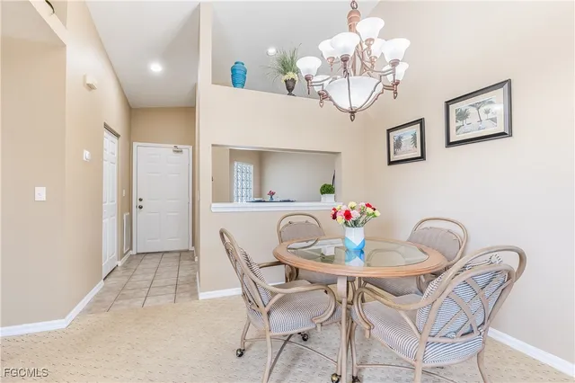 a dining room with wooden floor a chandelier a wooden table and chairs