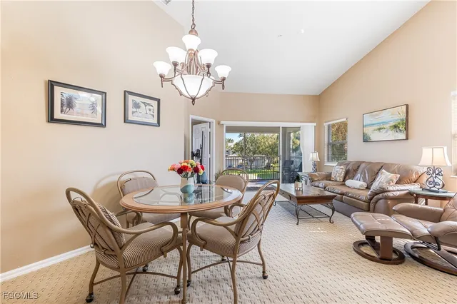 a view of a dining room with furniture a chandelier and wooden floor
