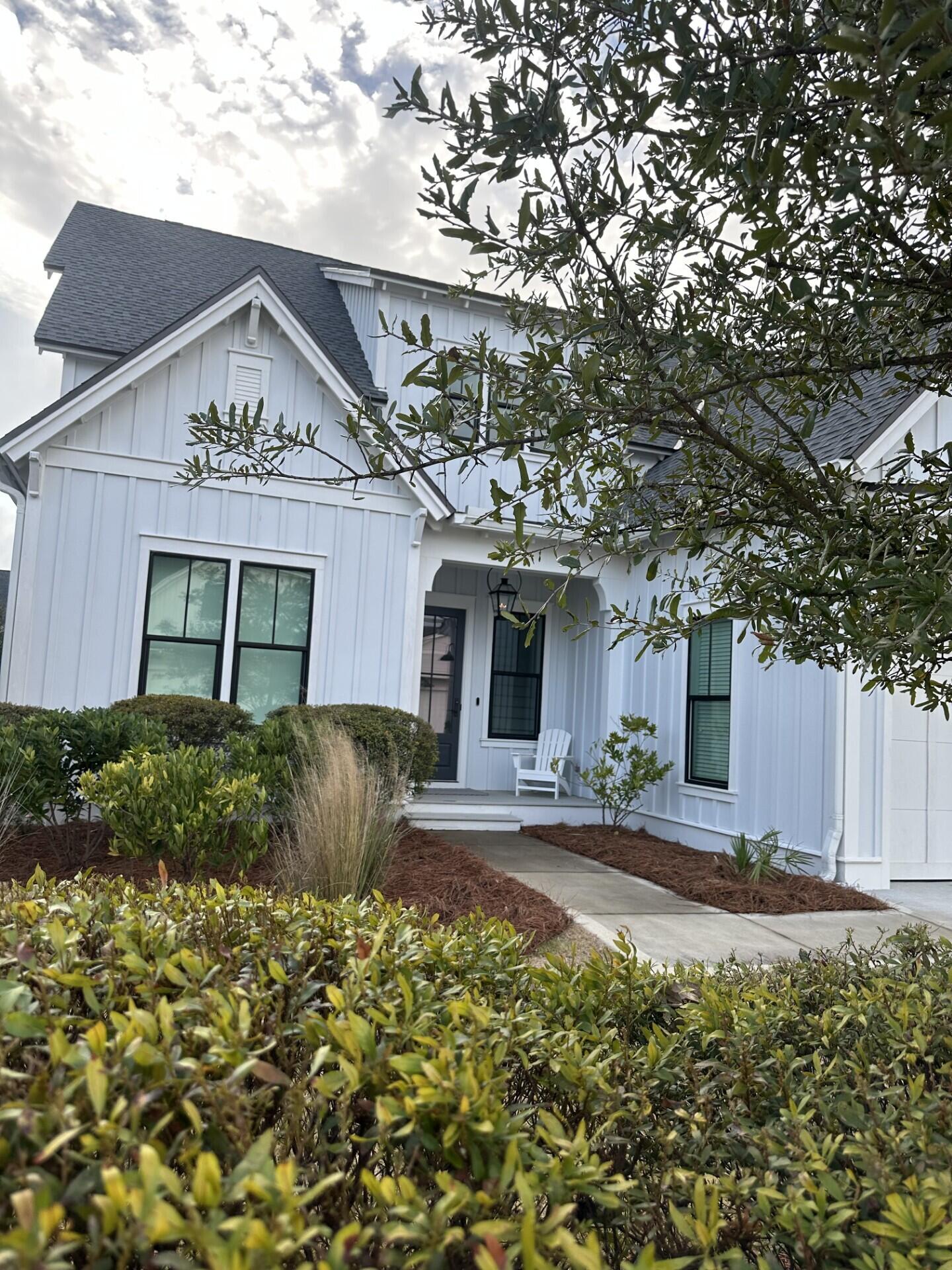 34 Heartwood Street Watersound, FL 32461 - Photo 9 of 42 a view of a white house with large windows and a small yard