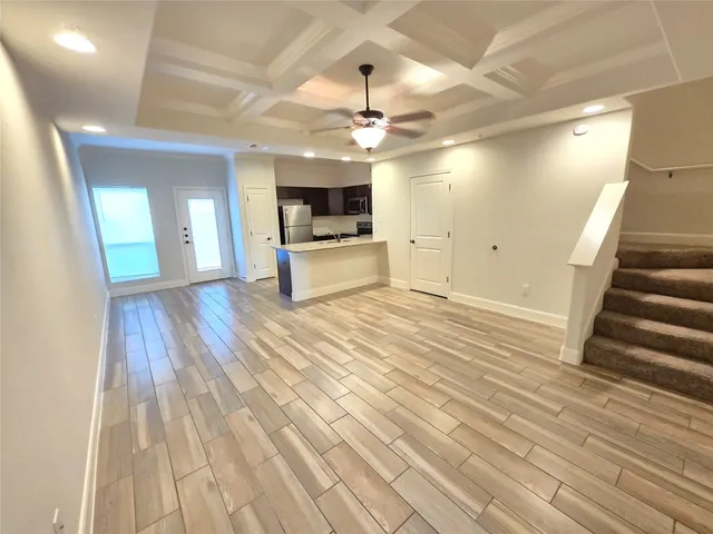a view of a kitchen with wooden floor and a ceiling fan