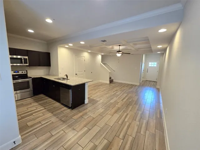 a kitchen with a sink and wooden floor