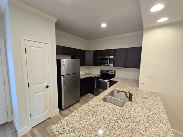 a kitchen with a refrigerator sink and cabinets