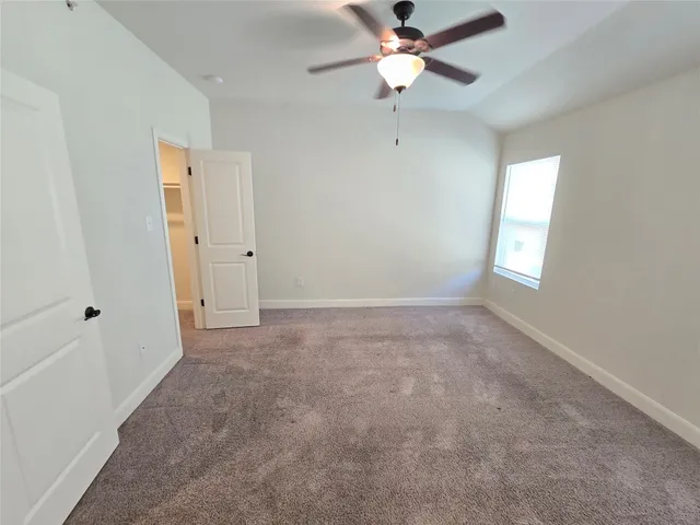 an empty room with a window and a fan