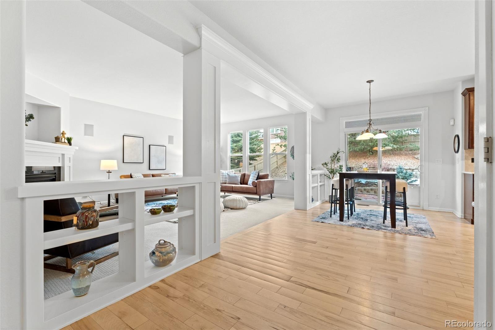 10683 Amesbury Way Highlands Ranch, CO 80126 - Photo 21 of 44 a living room with kitchen island granite countertop furniture and a wooden floor