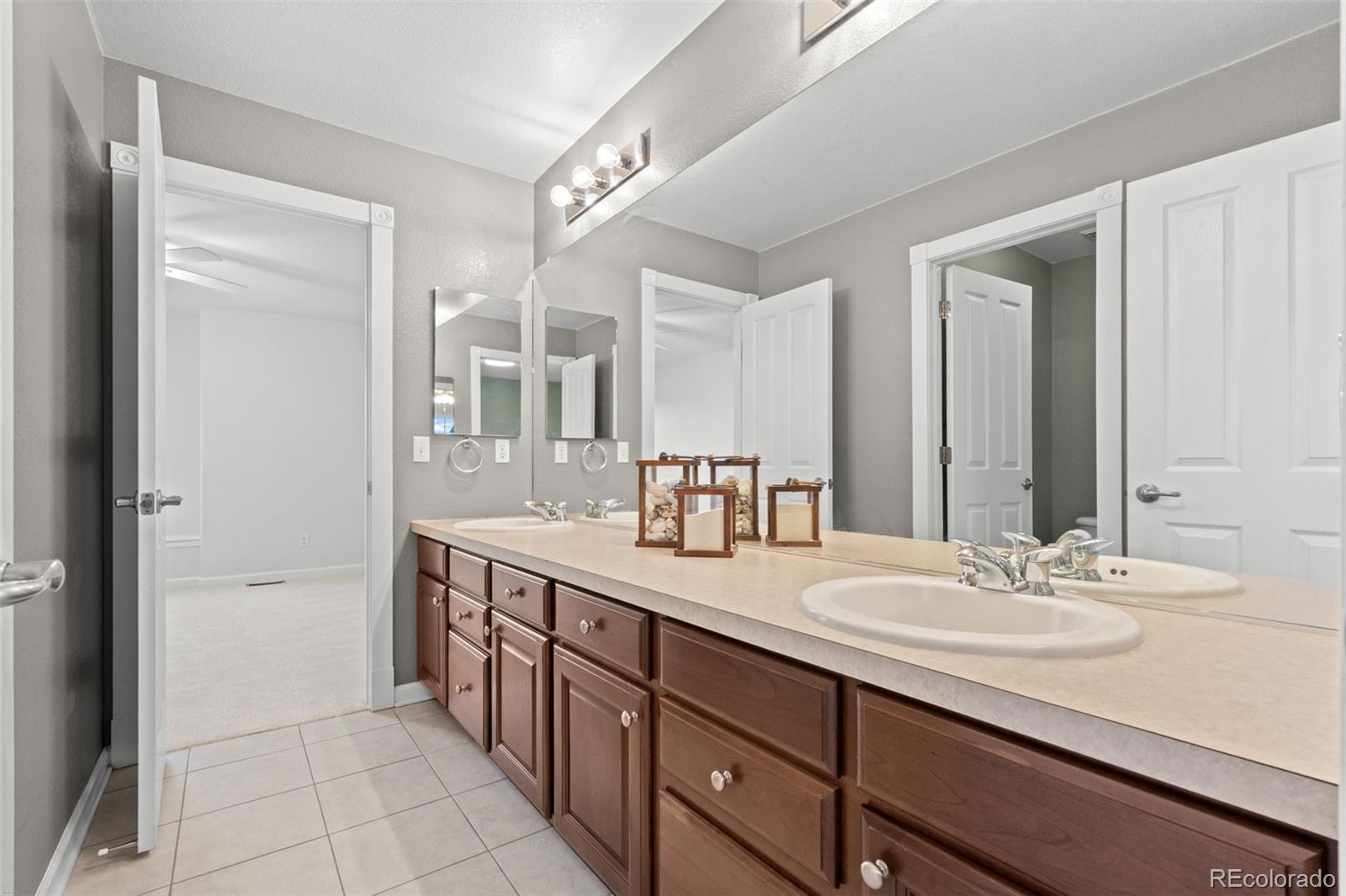 10683 Amesbury Way Highlands Ranch, CO 80126 - Photo 29 of 44 a bathroom with a double vanity sink a mirror and a shower