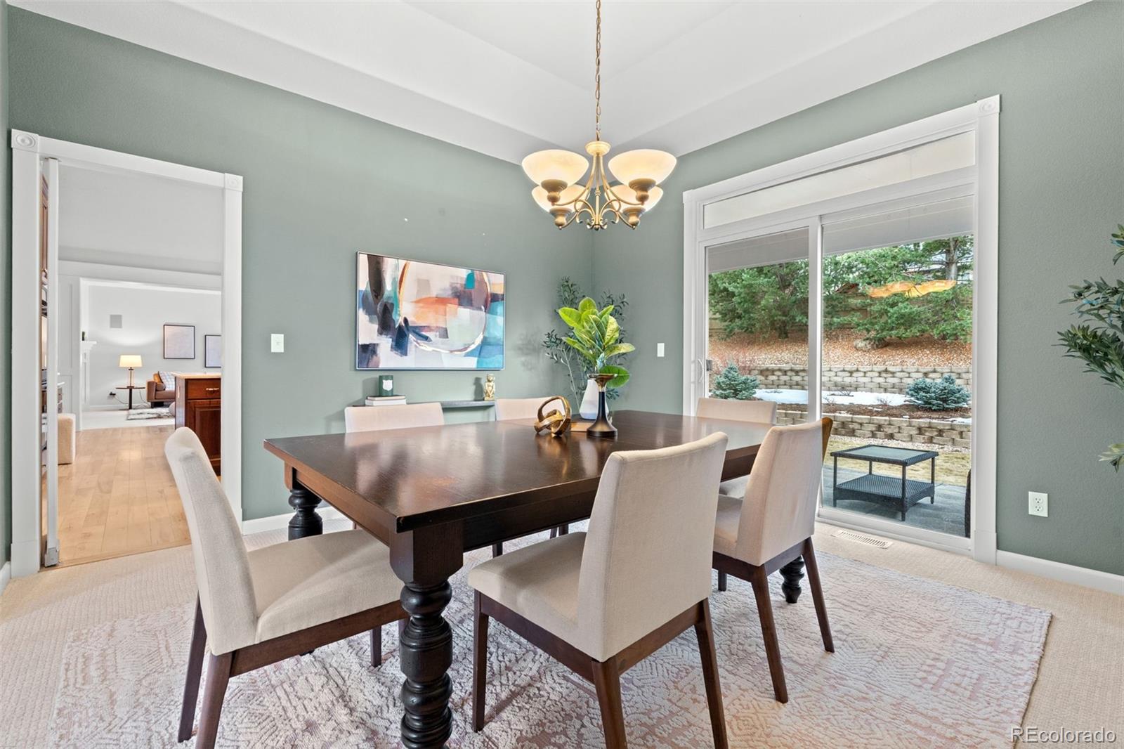 10683 Amesbury Way Highlands Ranch, CO 80126 - Photo 3 of 44 a view of a dining room with furniture a chandelier and wooden floor