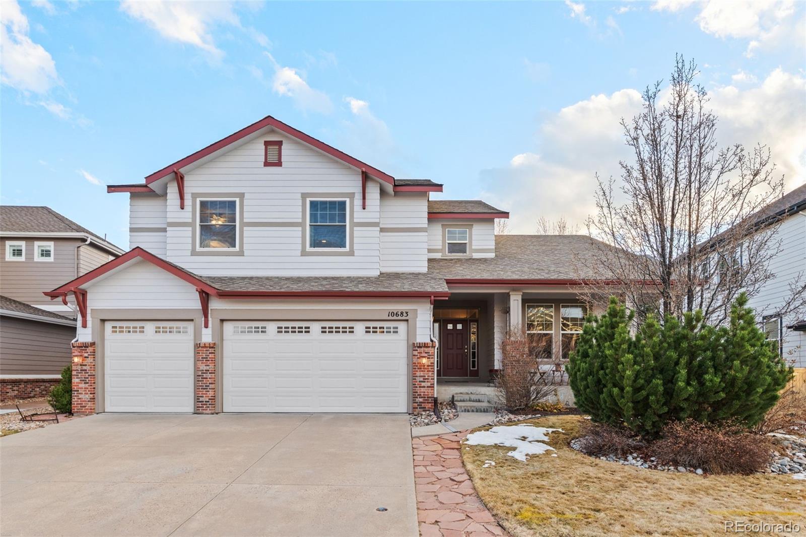 10683 Amesbury Way Highlands Ranch, CO 80126 - Photo 40 of 44 a front view of a house with a yard and garage
