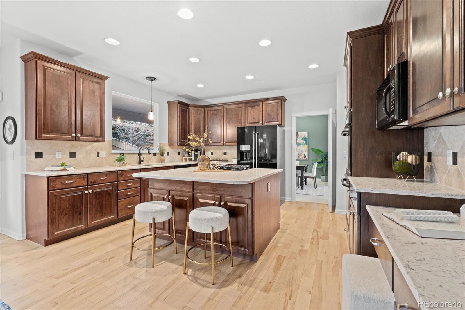 10683 Amesbury Way Highlands Ranch, CO 80126 - Photo 4 of 44 a kitchen with stainless steel appliances granite countertop sink stove refrigerator and cabinets