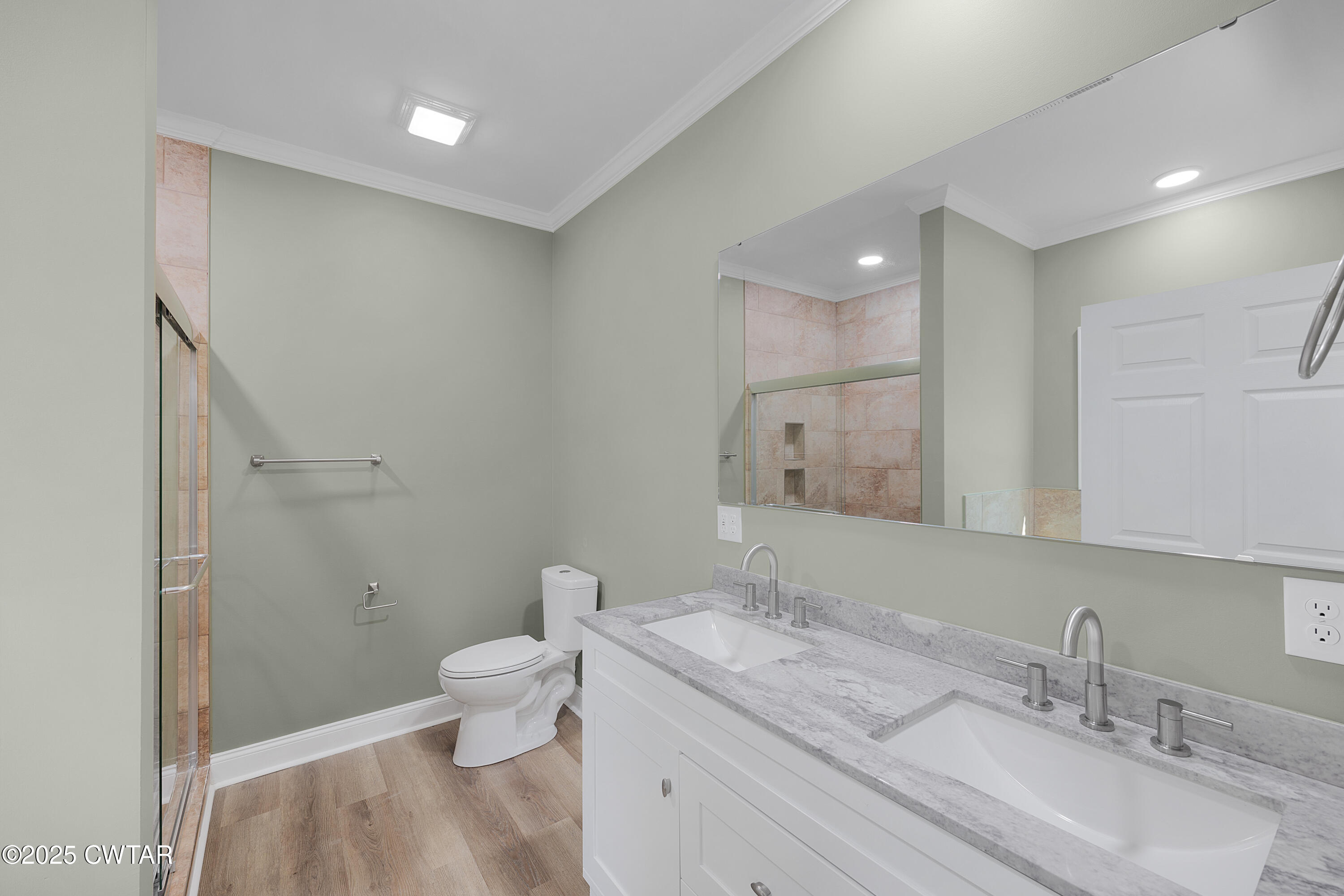 300 West Deaderick Street Jackson, TN 38301 - Photo 6 of 16 a bathroom with a granite countertop sink a toilet and a mirror