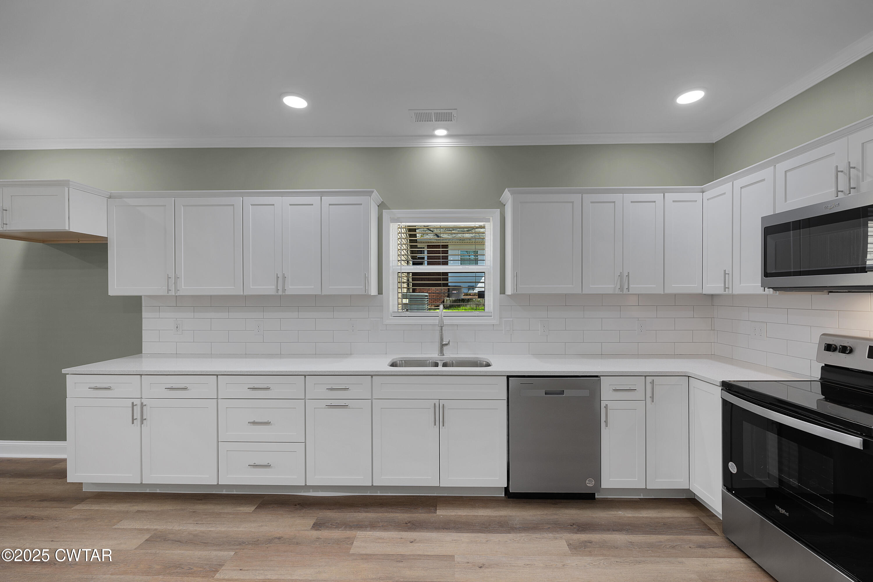 300 West Deaderick Street Jackson, TN 38301 - Photo 9 of 16 a kitchen with a sink stainless steel appliances and cabinets