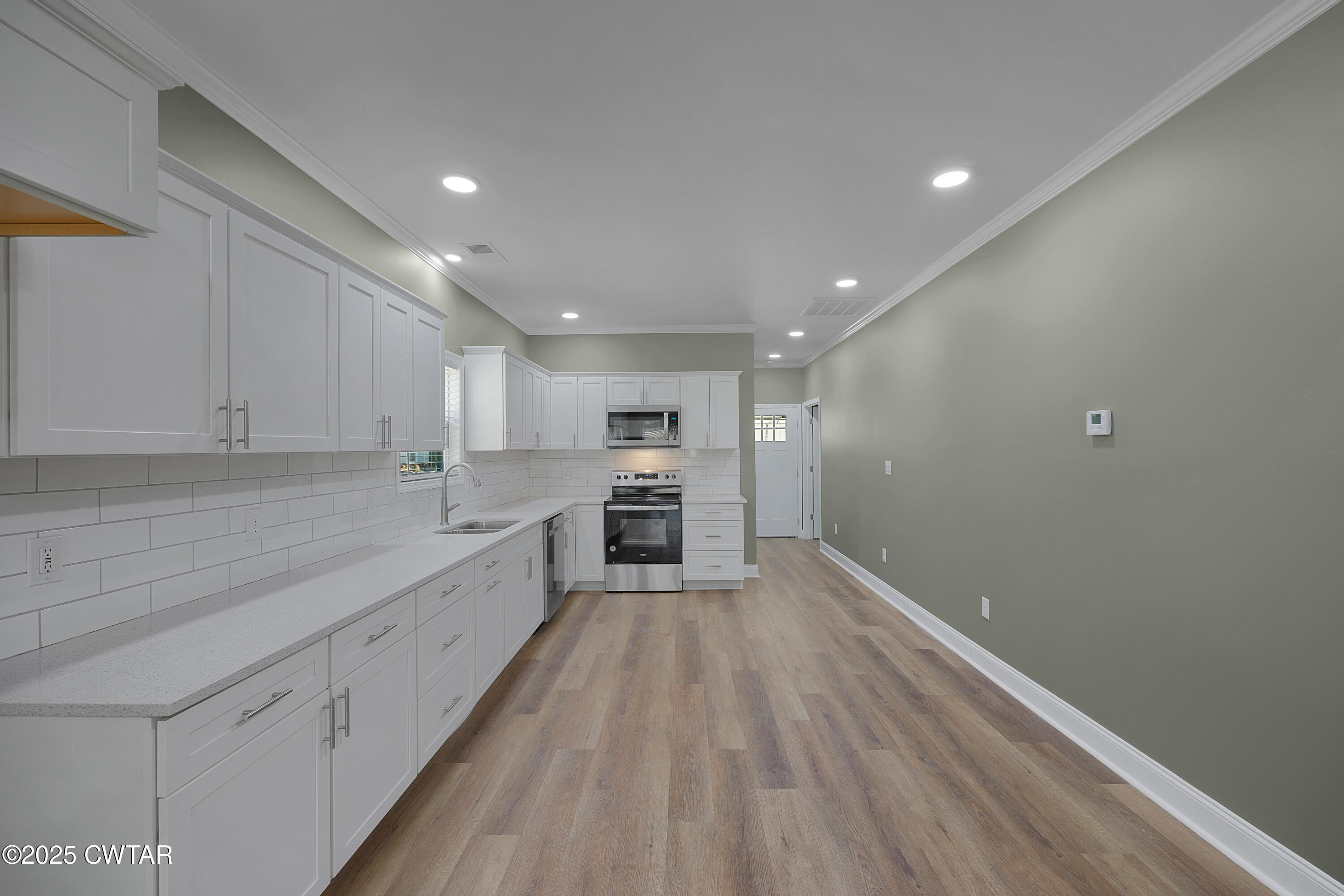 300 West Deaderick Street Jackson, TN 38301 - Photo 10 of 16 a large kitchen with a lot of counter space and wooden floor
