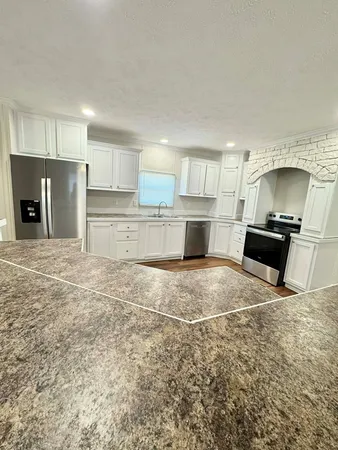 a large kitchen with kitchen island a sink stainless steel appliances and cabinets