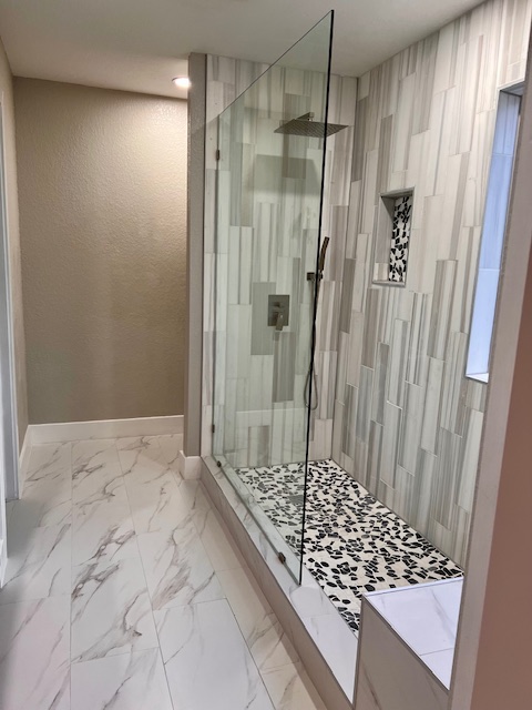 922 Gentry Drive Leander, TX 78641 - Photo 15 of 19 Bathroom with light marble finish flooring, a stall shower, and a textured wall