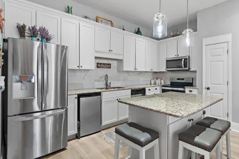 a kitchen with stainless steel appliances granite countertop a refrigerator stove microwave and sink
