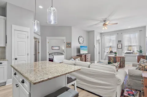 a living room with kitchen island furniture and a chandelier