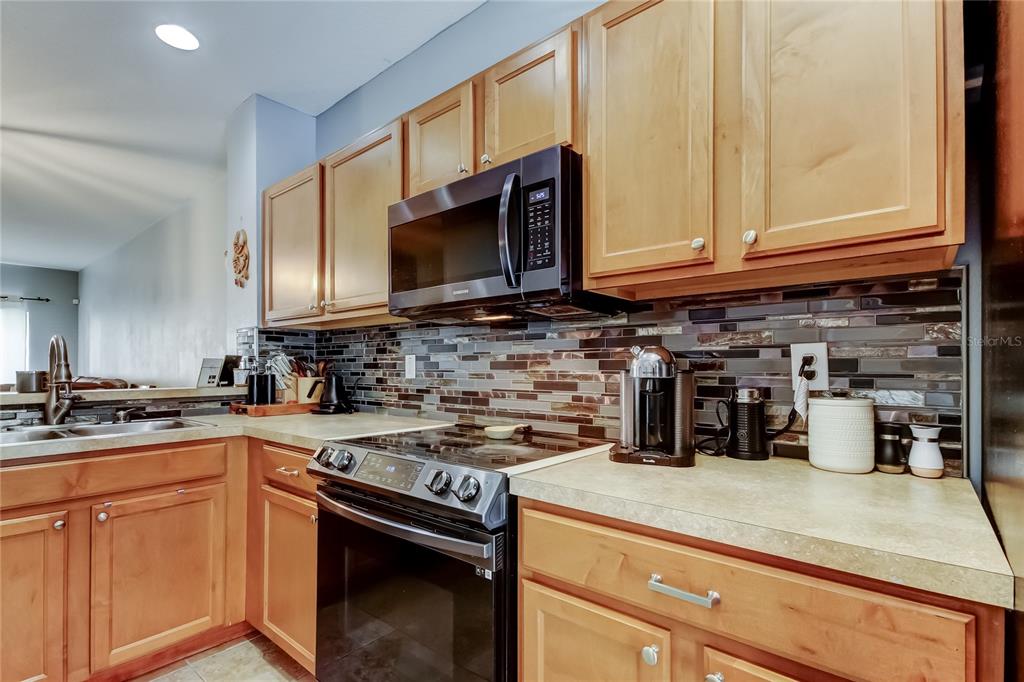 8504 Gablebend Way Tampa, FL 33647 - Photo 11 of 34 a kitchen with stainless steel appliances granite countertop a sink a stove a microwave and cabinets