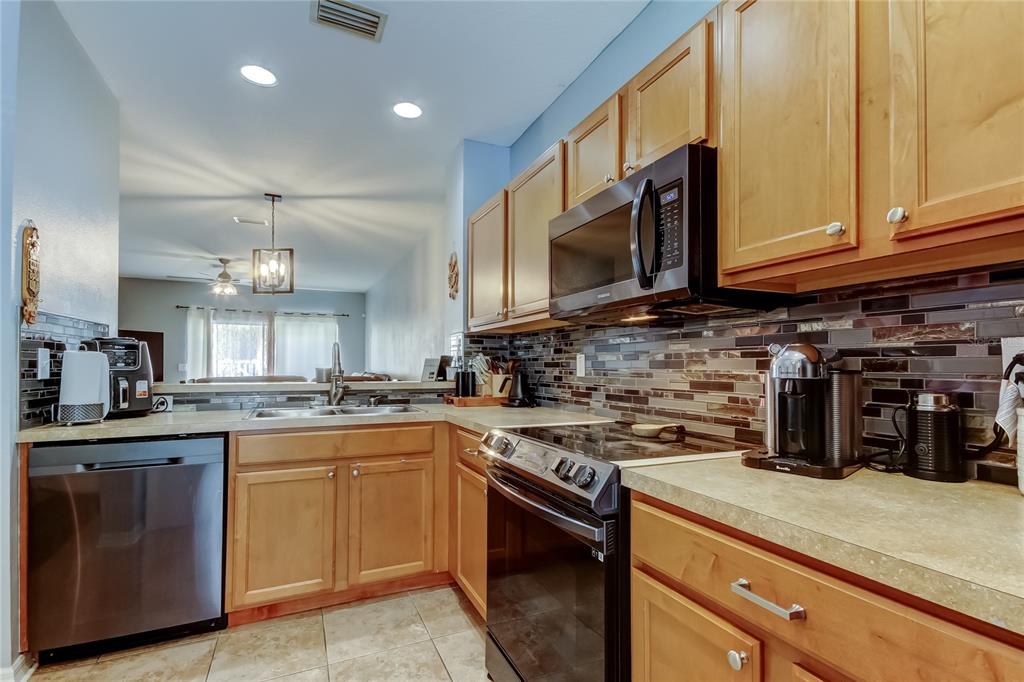 8504 Gablebend Way Tampa, FL 33647 - Photo 12 of 34 a kitchen with stainless steel appliances granite countertop a stove a sink dishwasher and a microwave oven with large cabinets