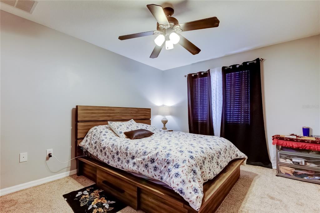 8504 Gablebend Way Tampa, FL 33647 - Photo 19 of 34 a bedroom with a bed and a chandelier