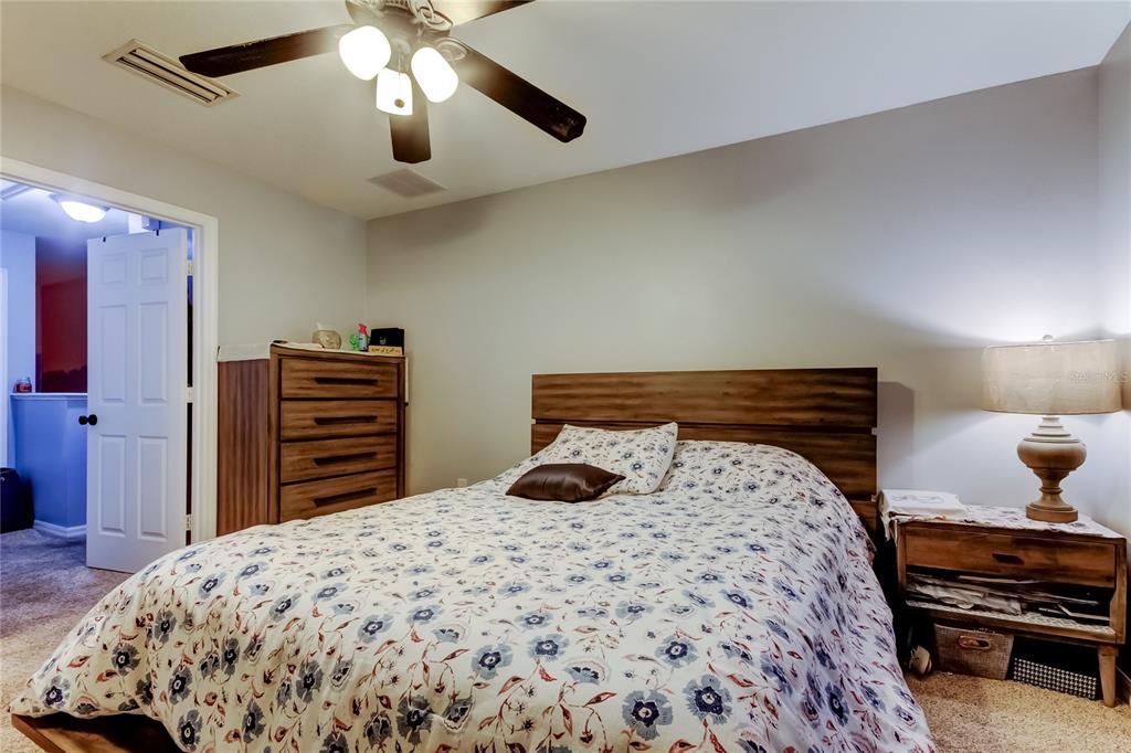 8504 Gablebend Way Tampa, FL 33647 - Photo 20 of 34 a bedroom with a bed and a chandelier