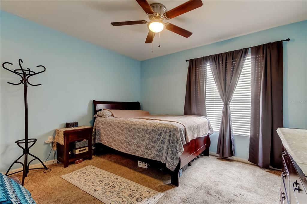 8504 Gablebend Way Tampa, FL 33647 - Photo 23 of 34 a bedroom with a bed and a chandelier
