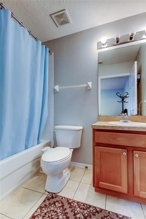 8504 Gablebend Way Tampa, FL 33647 - Photo 26 of 34 a bathroom with a sink a toilet a mirror and shower curtain