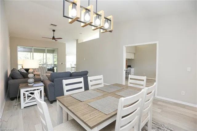 a view of a dining room with furniture a chandelier and wooden floor