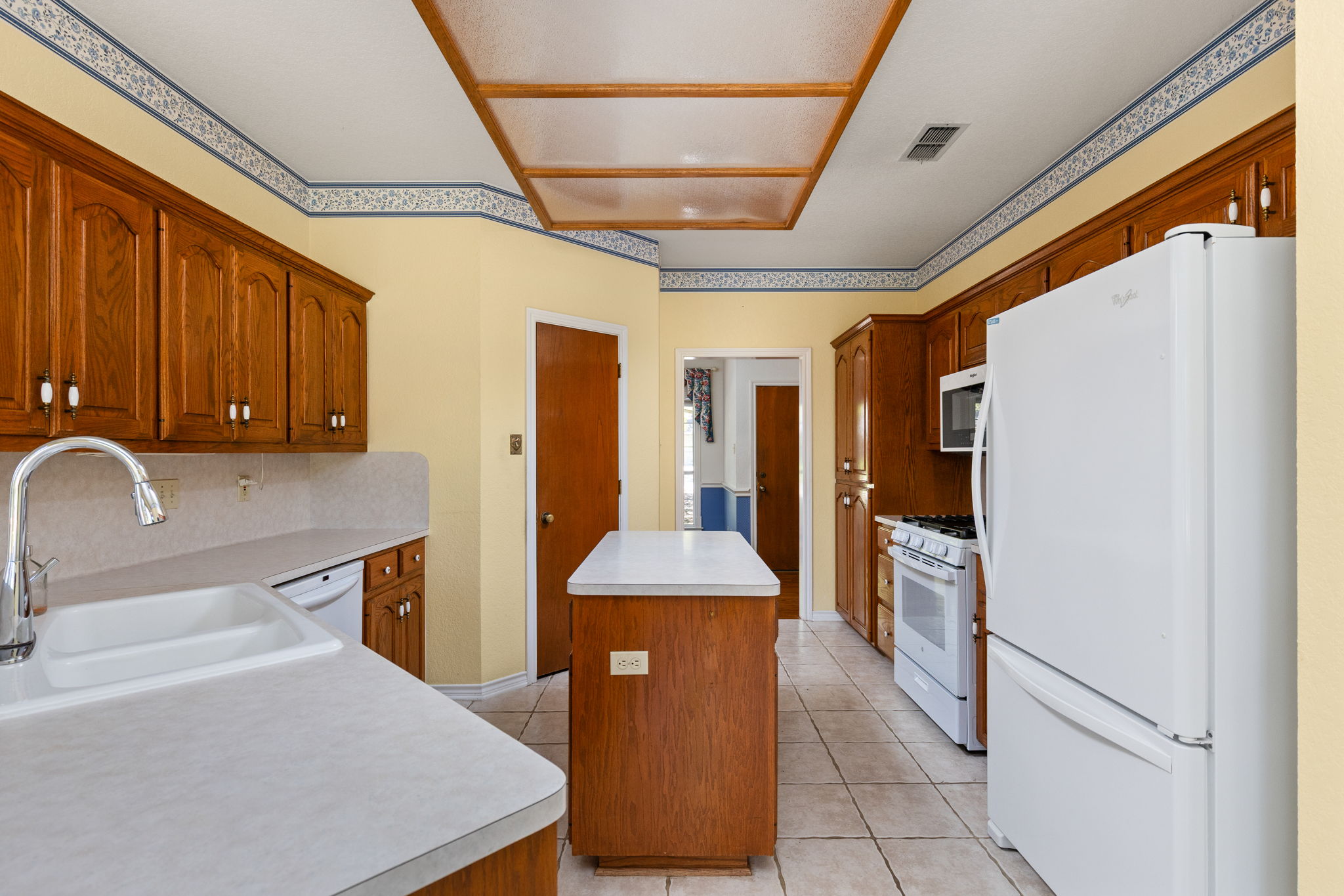 134 Canyon Road Georgetown, TX 78628 - Photo 12 of 40 Ample wooden cabinetry and structured tile flooring define this functional workspace.