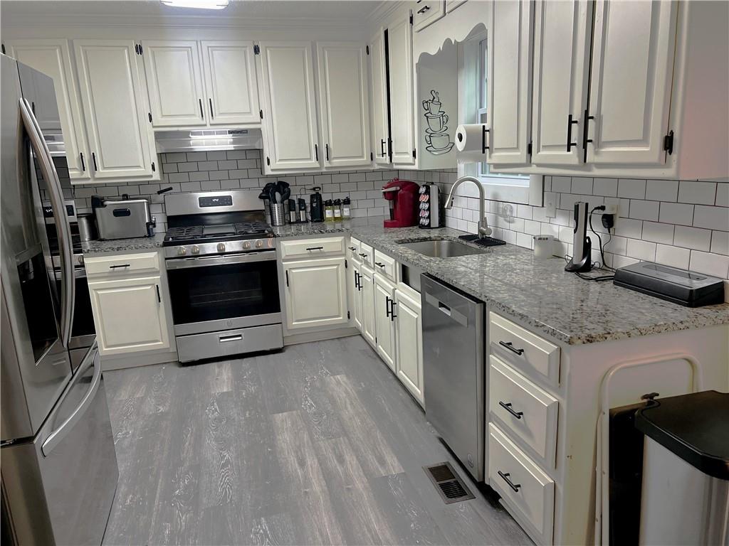 3735 Warwick Way Snellville, GA 30039 - Photo 7 of 28 a kitchen with granite countertop a sink stainless steel appliances and cabinets