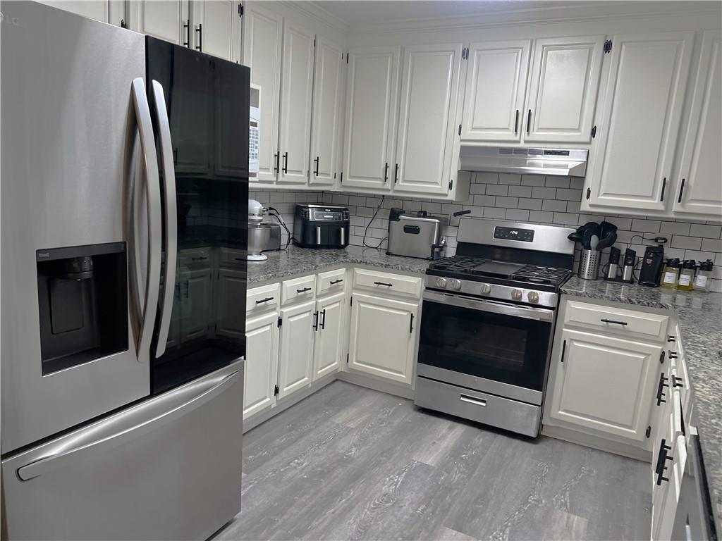 3735 Warwick Way Snellville, GA 30039 - Photo 8 of 28 a kitchen with white cabinets and stainless steel appliances