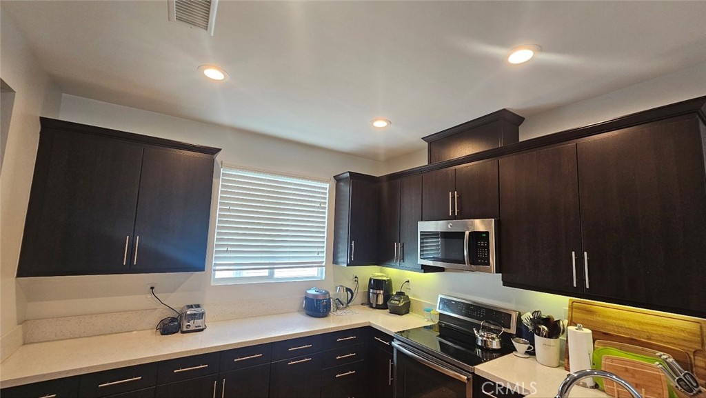 8073 Ackerman Street Buena Park, CA 90621 - Photo 10 of 43 a kitchen with a sink appliances and cabinets
