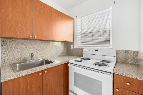a kitchen with a sink a stove and cabinets