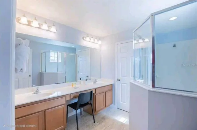 a en suite bathroom with a granite countertop sink and a mirror