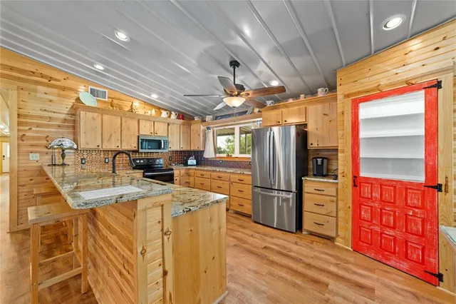 a kitchen with stainless steel appliances granite countertop a refrigerator a stove and a sink