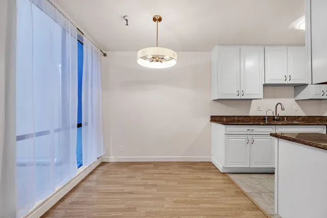 a kitchen with granite countertop cabinets a stove a sink and dishwasher