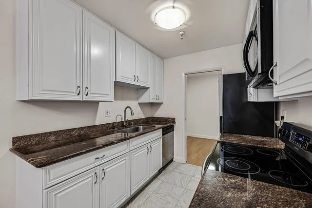 a kitchen with stainless steel appliances granite countertop a sink stove and cabinets
