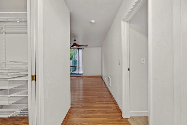 a view of a hallway with wooden floor and staircase
