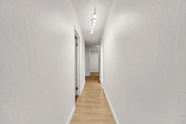 a view of a hallway with wooden floor